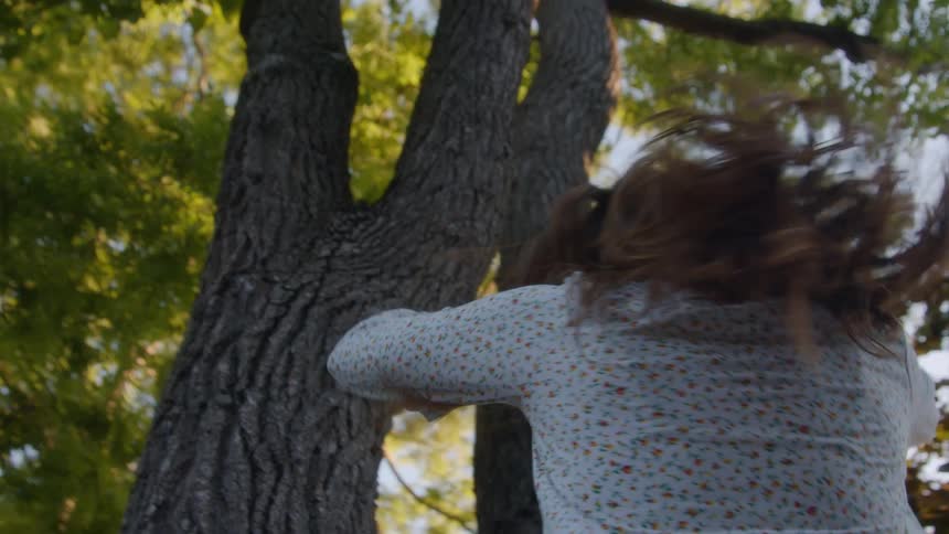 Woman spinning under tree