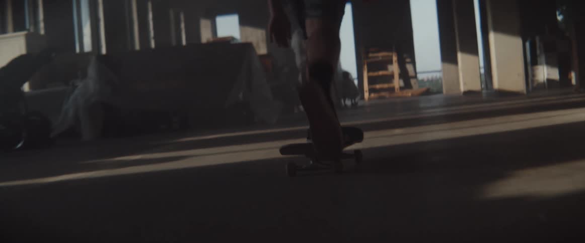 A male skateboards through a building