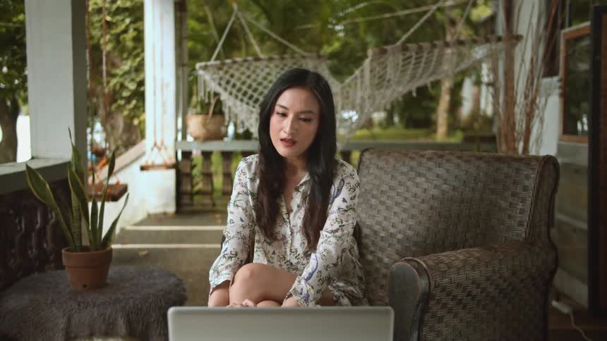 While having a video conversation on her laptop a woman goes from being happy to looking disappointed