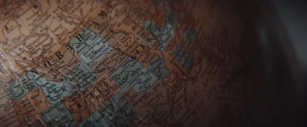 Close up of the mapped surface of an earth globe in a dimly lit room
