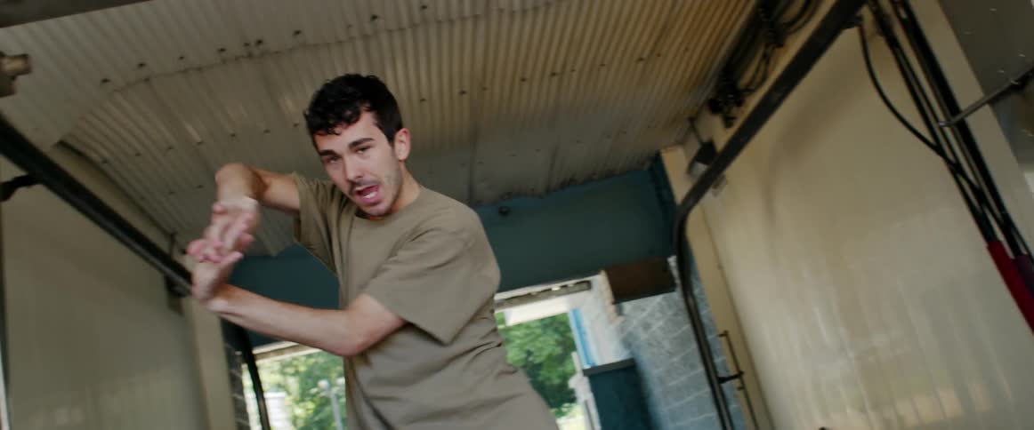 Young man dancing energetically inside a car wash
