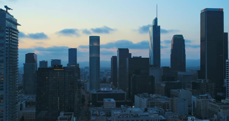 A city downtown and skyline glow with lights at dawn