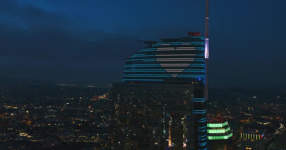 Orbiting shot of a skyscraper with led art on it at night