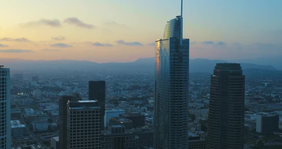 A city skyline with buildings and skyscrapers with the sky and clouds in the background