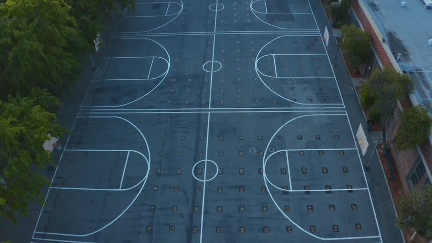 Series of empty basketball courts sit just behind long building