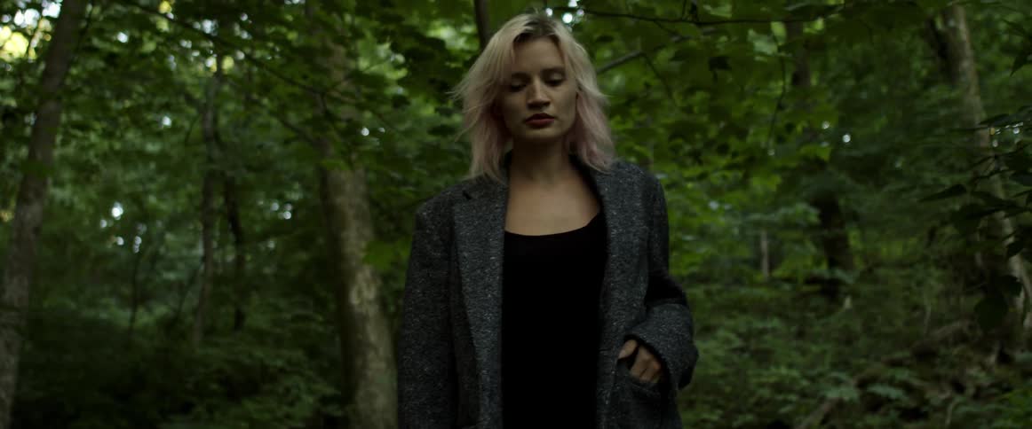 A woman is walking through a forest in spring