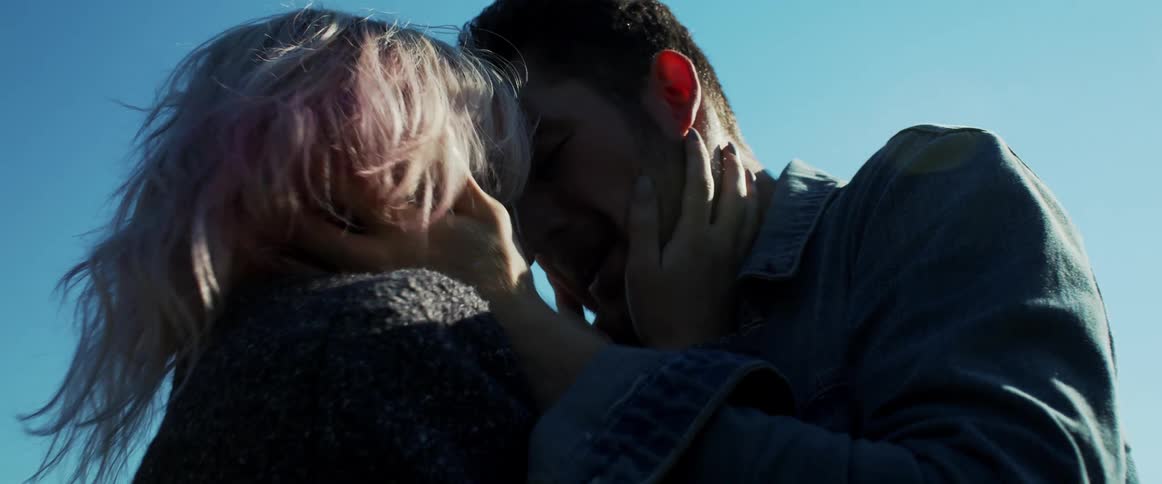 Man and woman embrace lovingly under the blue sky