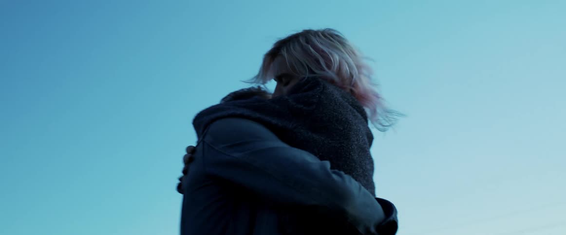 A man picks up a woman as he hugs her outdoors