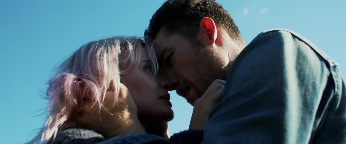 A man grabs his girlfriends face and pulls her in close