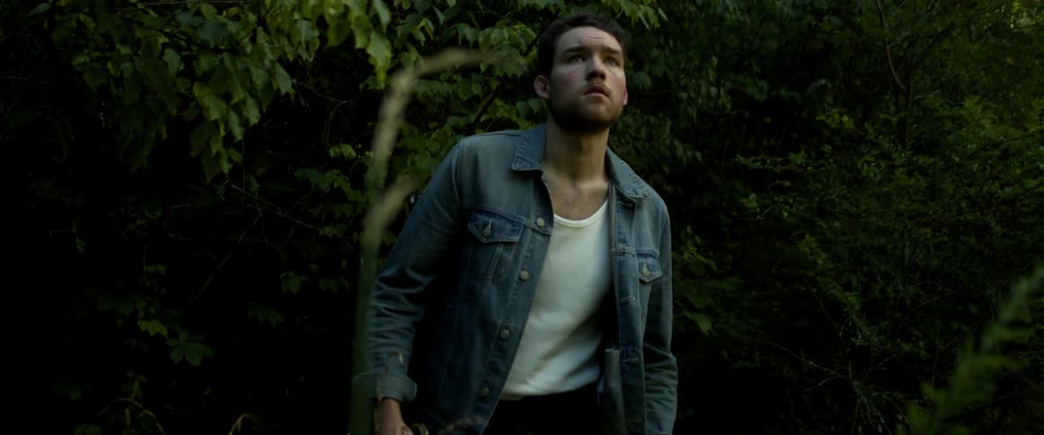 A young man emerges from a forest