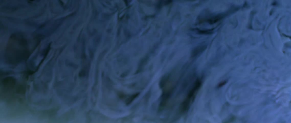 Clouds of gray blue flow and collapse smoothing into a soft glowing light