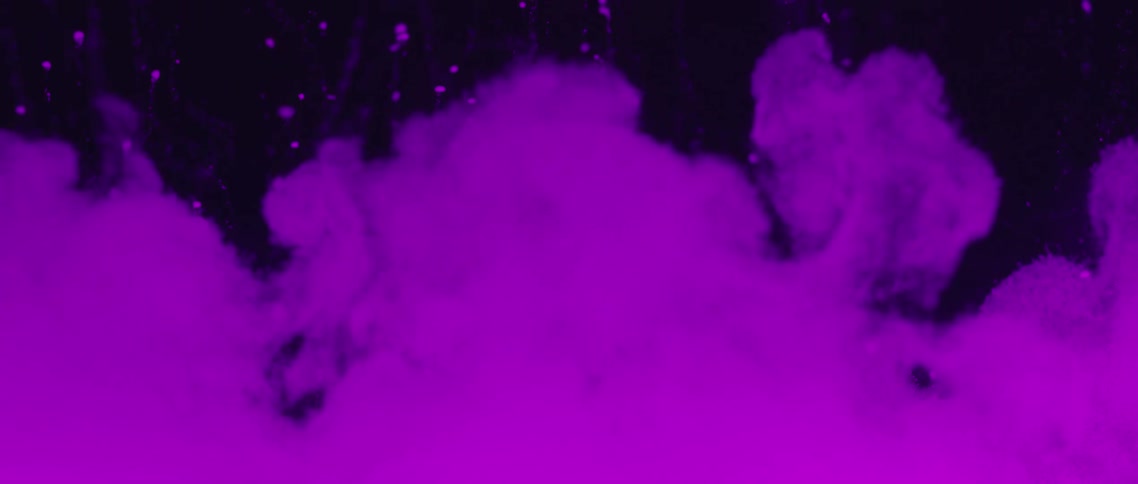A view of smoke in slow motion with purple lighting on it