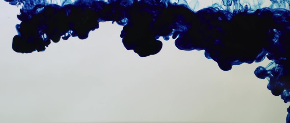 Blue ink spreads over the surface