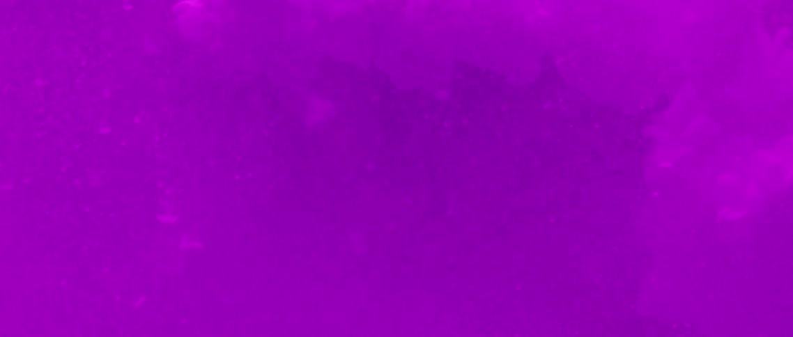 Purple light shines on the snowflakes and purple smoke