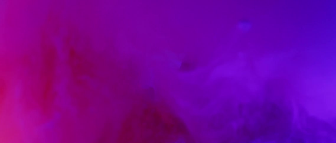 Smoke changes colors going through purples and pinks as particles fall