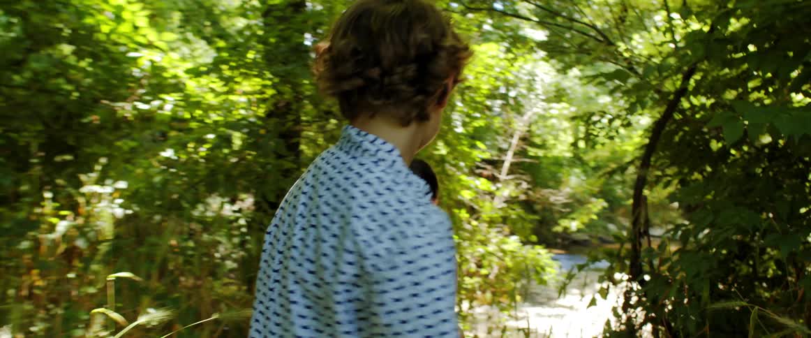A boy and girl walking outdoors in a forest