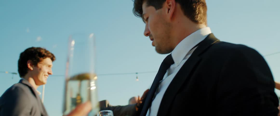 A groom dances with his bride and friends at an outdoor wedding reception