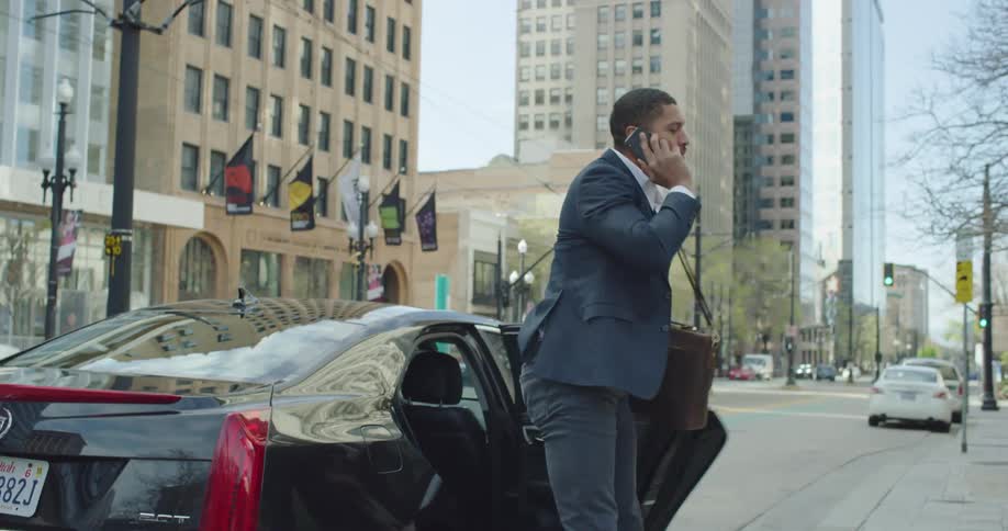Businessman checks his smartphone out and walks away