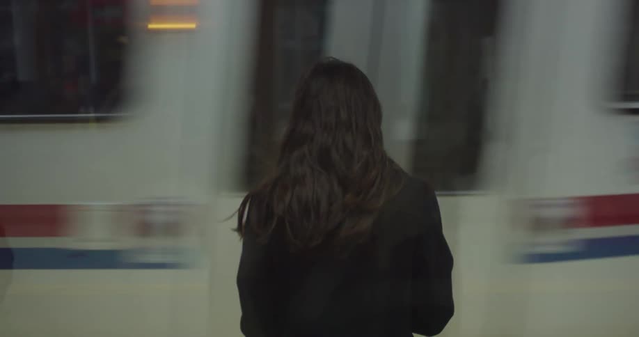 A woman stands on the side of a city street