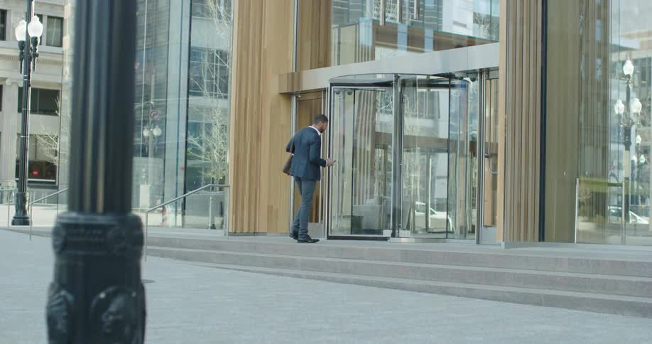 A man with a briefcase walks into a building