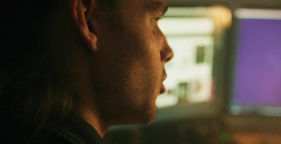 Man talking in front of a computer screen