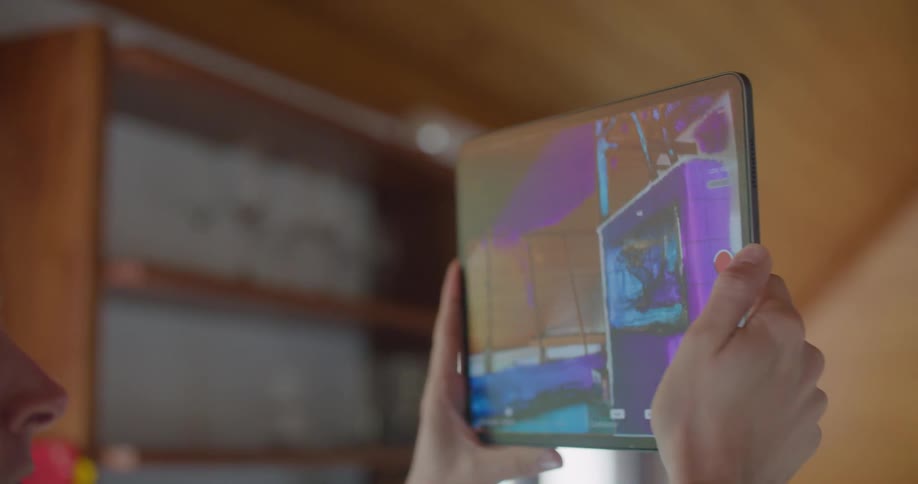 A man uses his tablet to scan a room in 3D