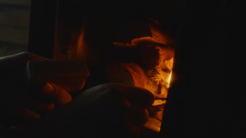 A man lights a fire in his home