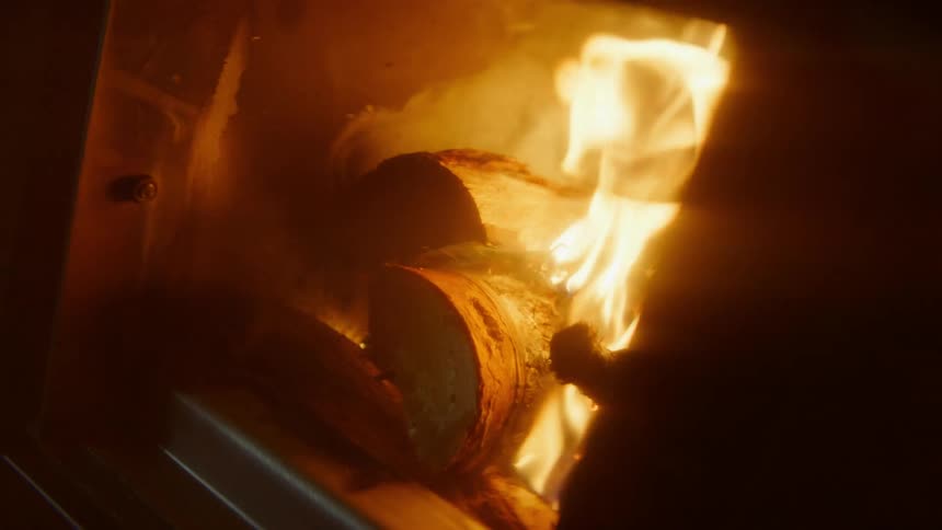 Logs of wood burn inside of an oven