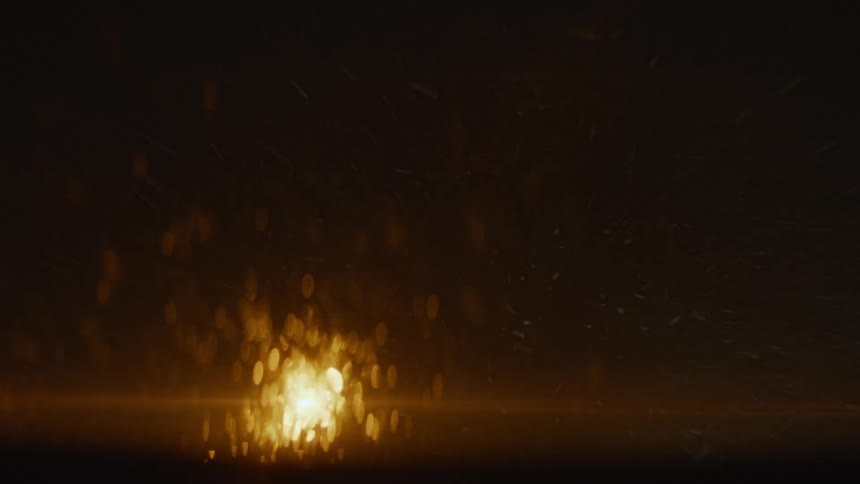 Rain falling on glass smears light source creating glare and light smear