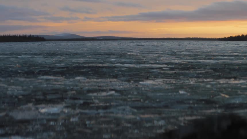 Ice covered lake under a cloudy orange sky