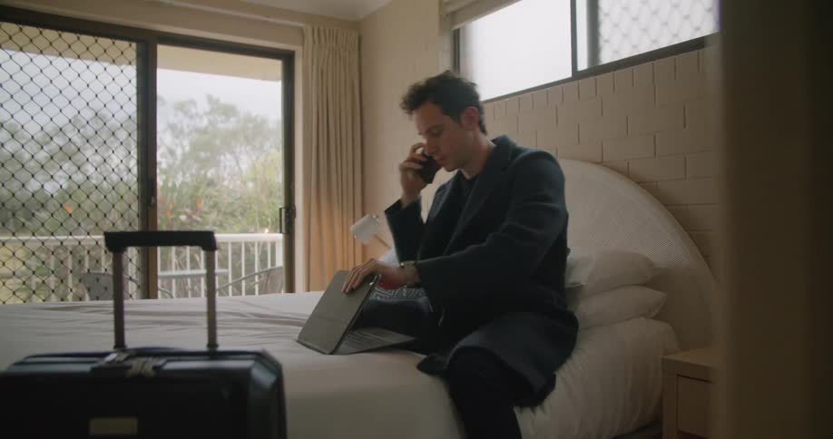 An employee opening a computer and talking on a phone