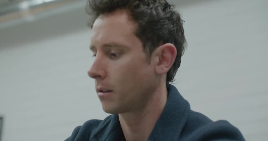 Man wearing coat folds clothes taking time to match socks