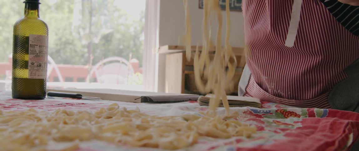 A woman making homemade pasta in a home kitchen
