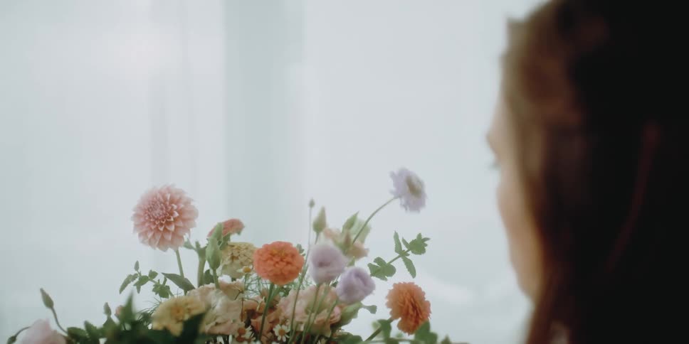A woman putting together a floral arrangement