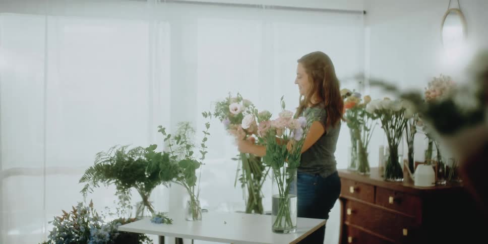 Woman arranging flower bouquets on the living room