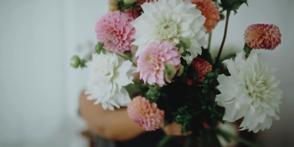 Happy woman shows a flower bouquet at the camera