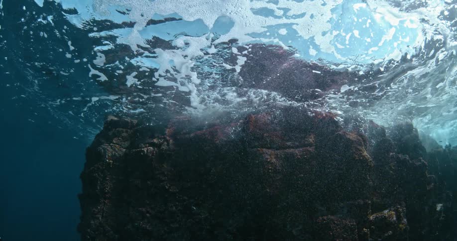 Ocean water flows around a large rock