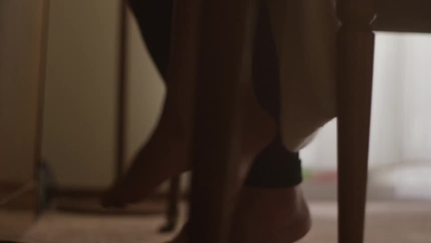 An adult and a child sit on chairs swinging their feet