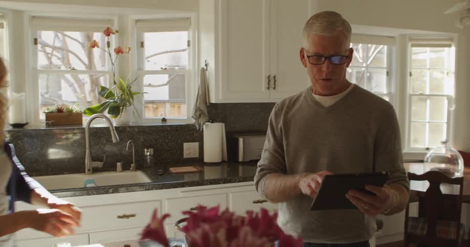 Mature couple cooking dinner in the kitchen at home