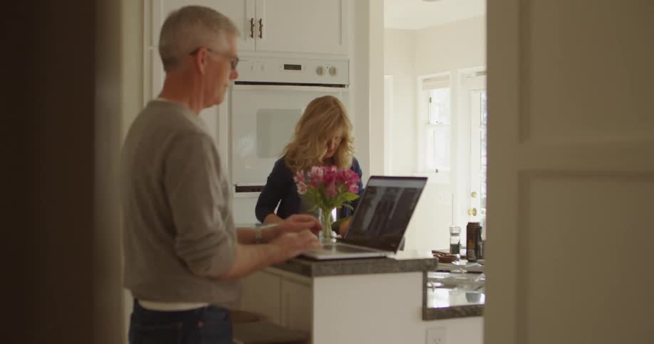 Married couple working and making diner on the kitchen at home