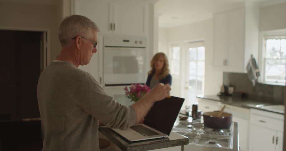 A man and woman talking in a kitchen