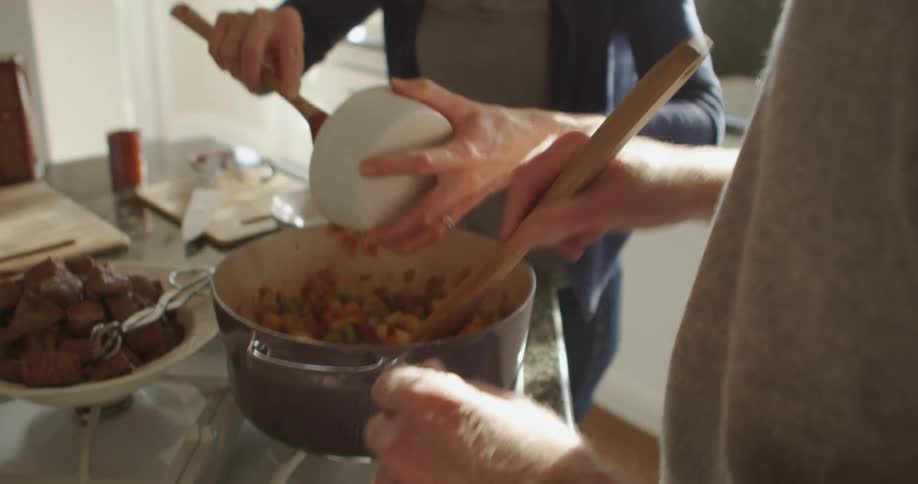Mature couple cooking dinner together in the kitchen at home