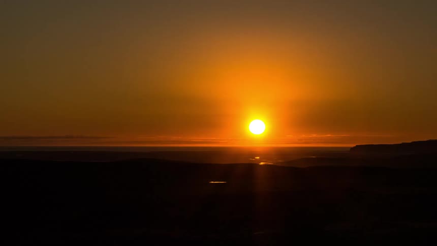 Sun setting over the beach in a red sky