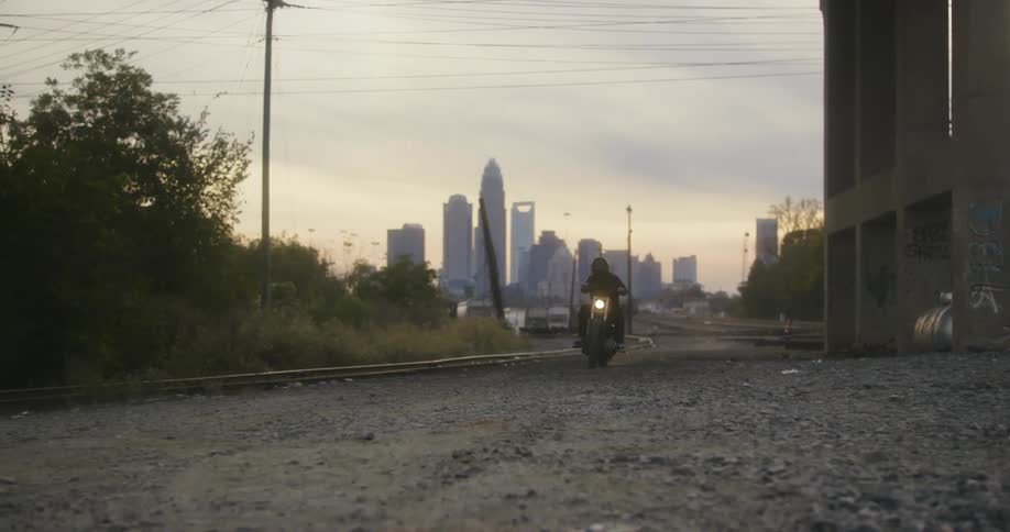 A person is riding a motorcycle at dusk