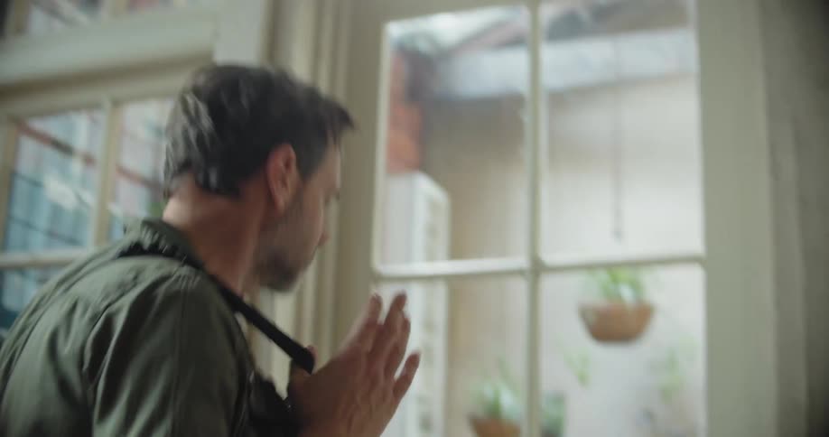 A man searches drawers and a box in a home in an anxious and frustrated manner