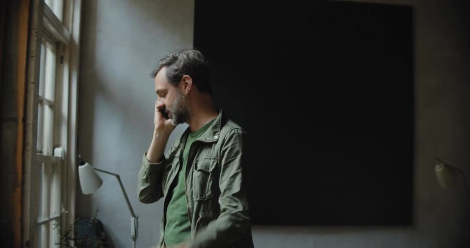 Man energetically talking on the phone inside a studio