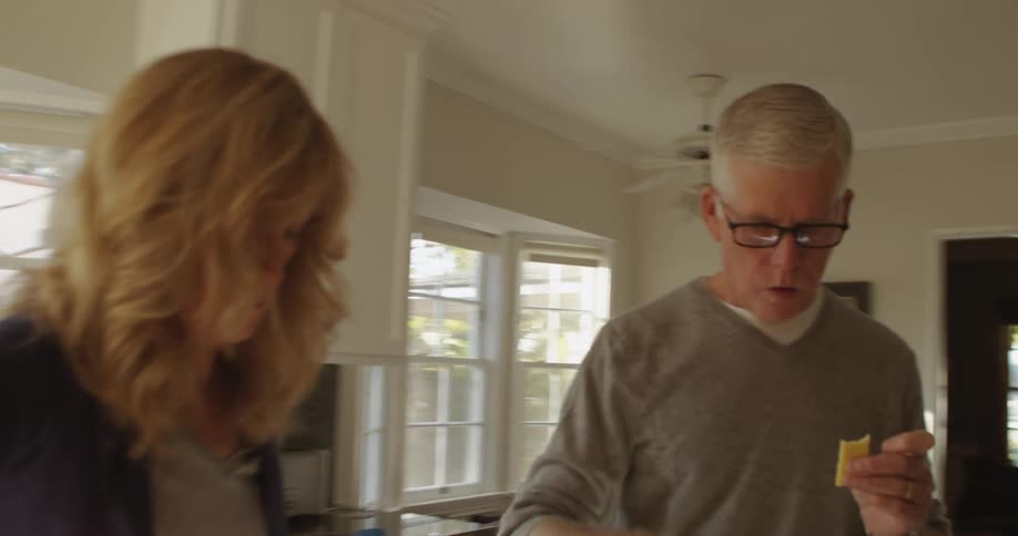 A couple is cooking in a kitchen and tasting the food