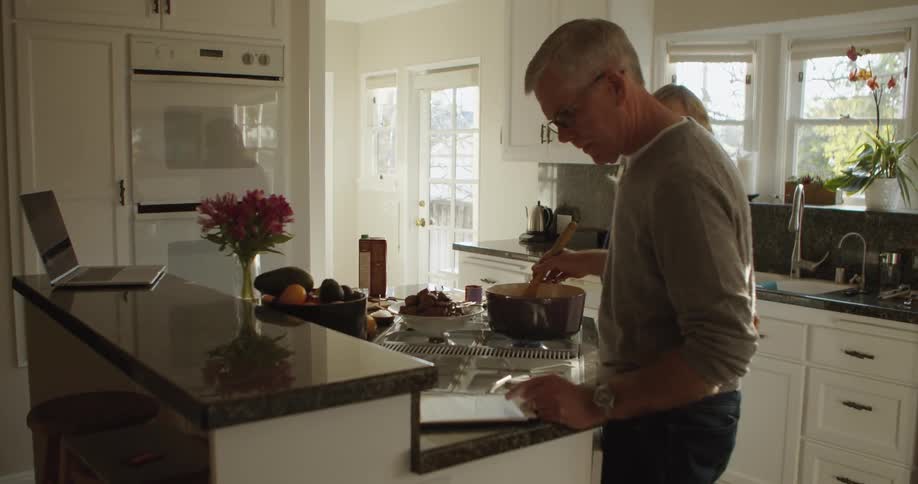 Mature couple making dinner at home