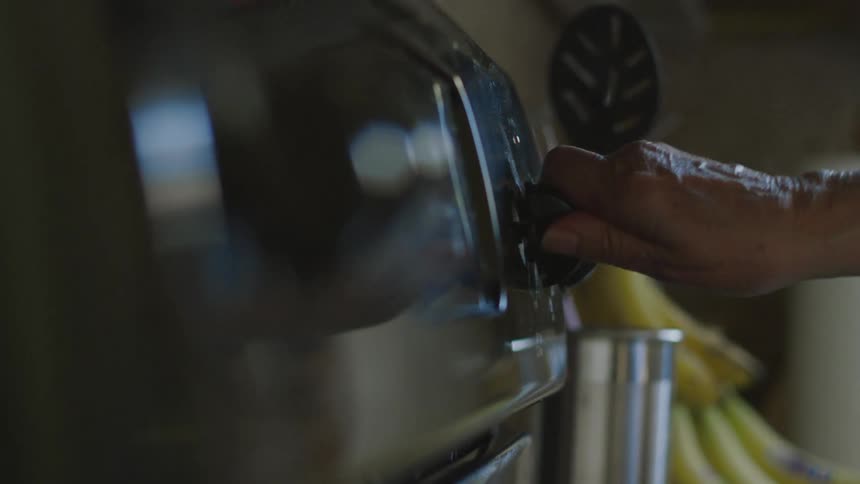 A man turns on a knob on his stovetop