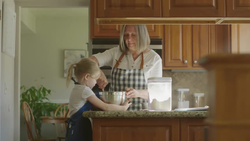 Grandmother and granddaughter cooking in the kitchen at home